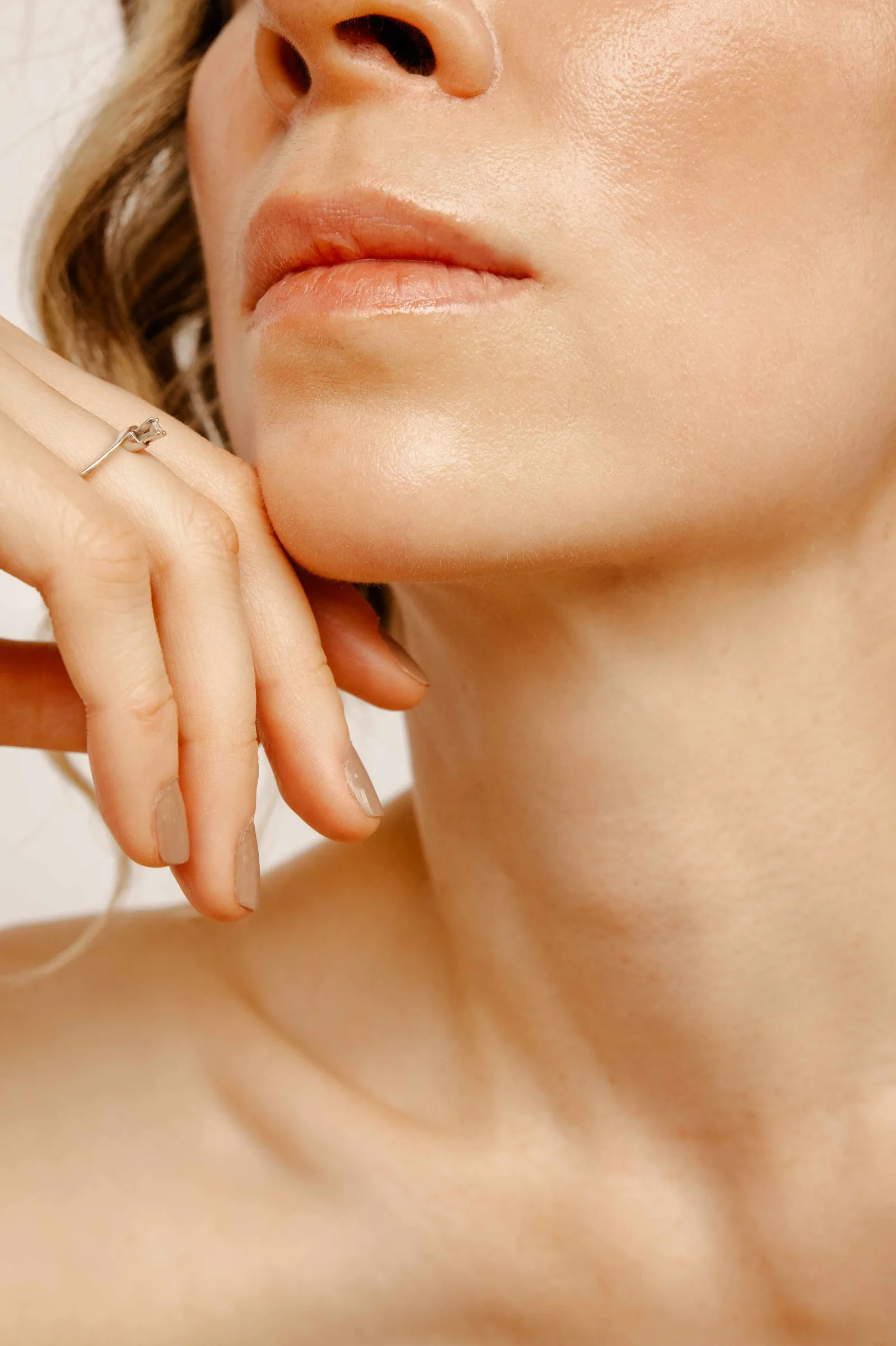 Piel luminosa y natural — detalle editorial de rostro y cuello de paciente con piel hidratada en Clínica Ohmio